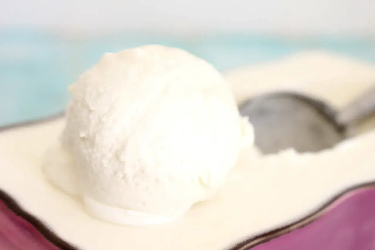Una bola cremosa de helado de nata sobre un plato, lista para ser disfrutada.