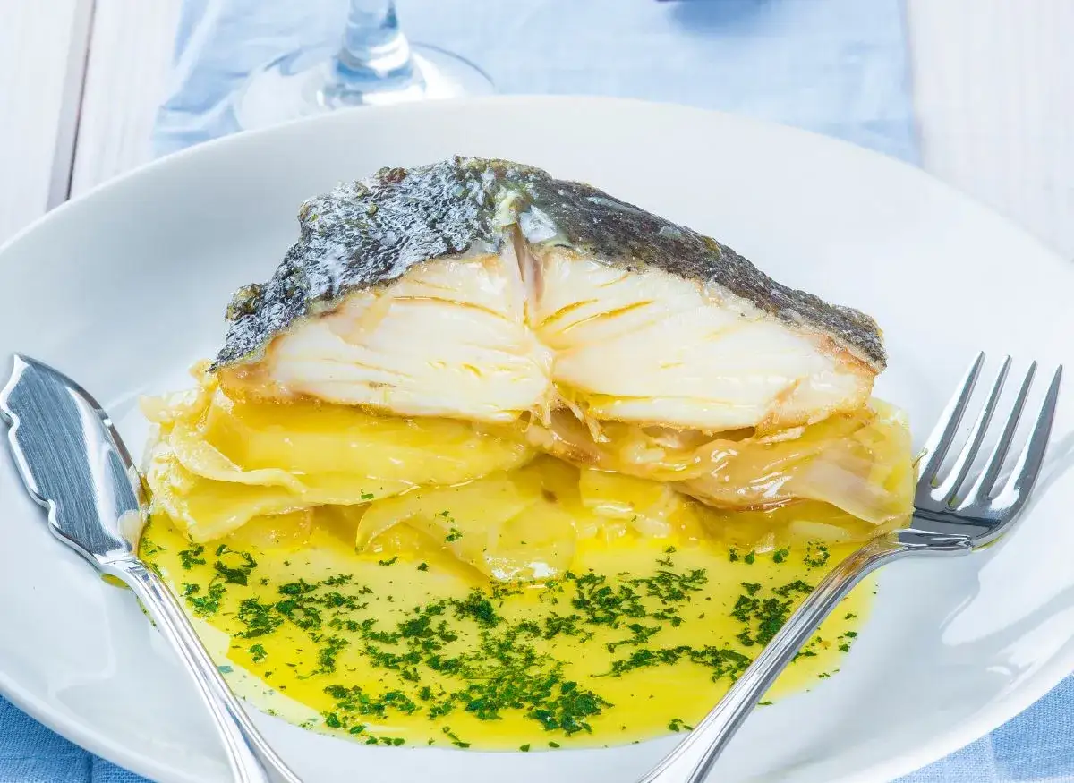 Merluza jugosa en airfryer sobre patatas y cebolla, ba&ntilde;ada en aceite de oliva y perejil.