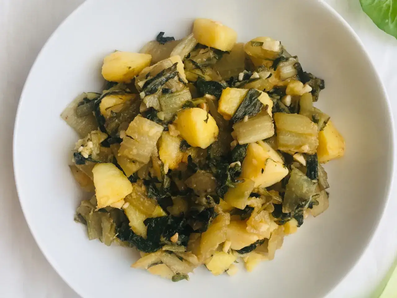 Plato de patatas y acelgas salteadas, una de las muchas recetas con acelgas que puedes preparar.