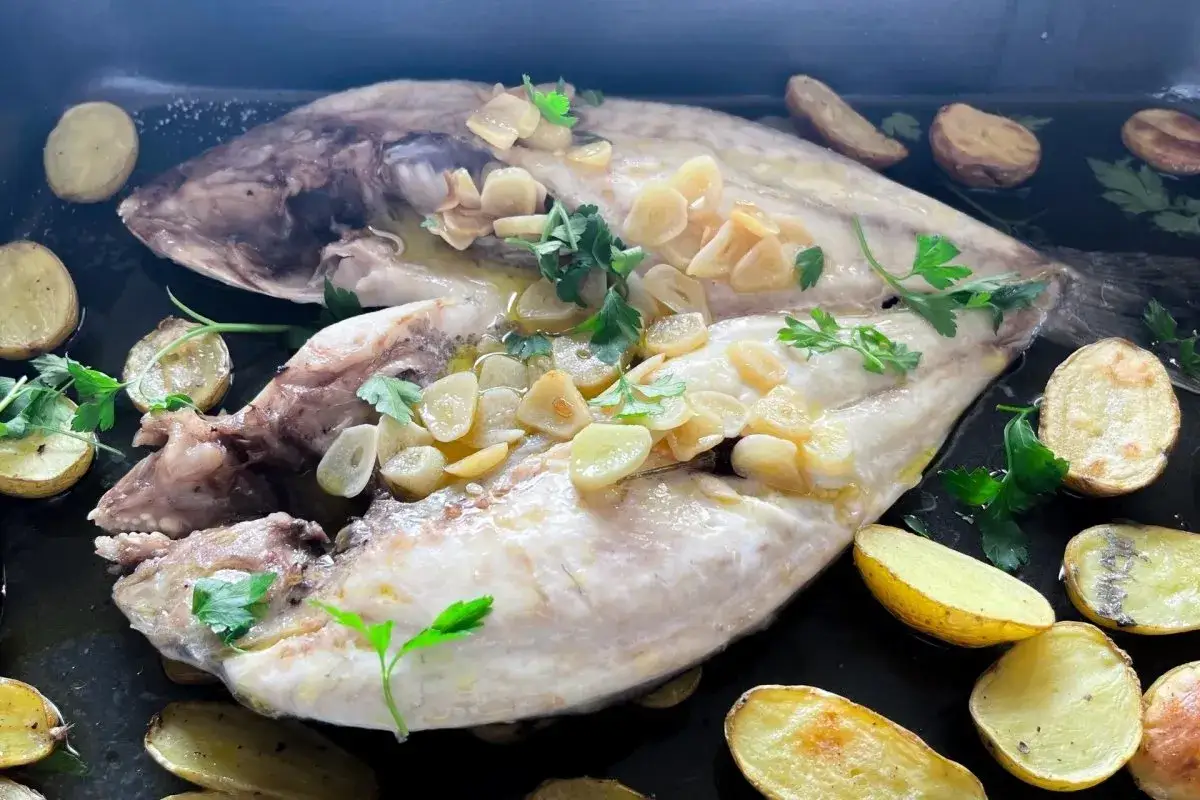 Dorada a la espalda, jugosa y tierna, con patatas asadas y ajo laminado. Un plato sencillo y delicioso.