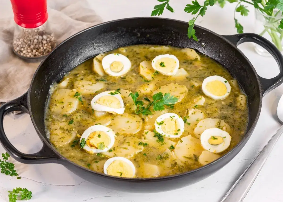 Patatas en salsa verde con huevos cocidos, un plato reconfortante y lleno de sabor, listo para disfrutar.