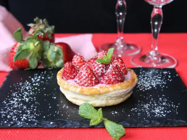 Tarta de fresas con crema rosa, espolvoreada con azúcar glas y menta. Perfecta para acompañar vinos de postre.